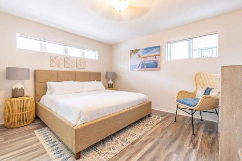 ein Schlafzimmer mit einem großen Bett und einem Stuhl in der Unterkunft Delightful Cottage in Seaside Town of La Jolla Village in San Diego