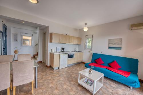a living room with a blue couch and a kitchen at Glyfa Corfu Apartments in Barbati