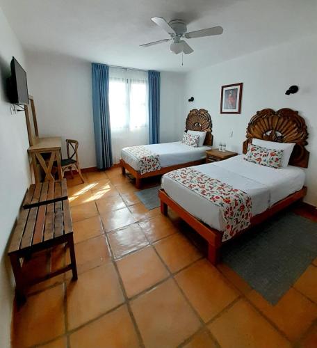 a hotel room with two beds and a fan at Hotel La Lejona in San Miguel de Allende