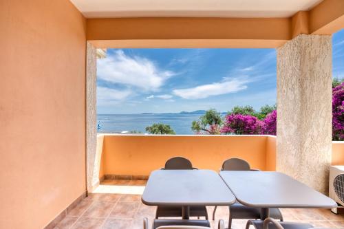 a room with two tables and a view of the ocean at Glyfa Corfu Apartments in Barbati