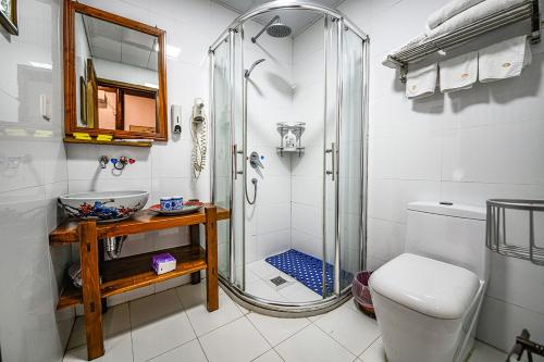 a bathroom with a shower and a toilet and a sink at Hui Boutique hotel in Huangshan