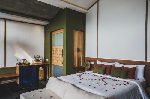 a bedroom with a large bed with red flowers on it at Amora Ubud Boutique Villas in Ubud