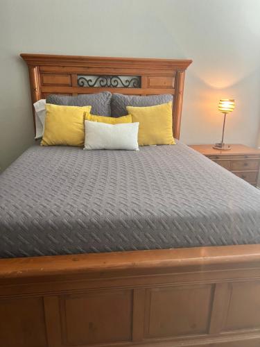 a bed with a wooden headboard and yellow pillows at Cowtown 1 bedroom in Downtown FT Worth in Fort Worth