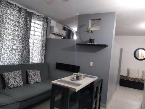 a living room with a couch and a table at Departamentos de la Reina Roja in Palenque