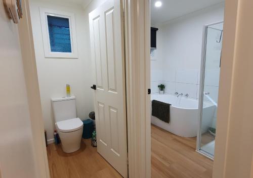 a bathroom with a tub and a toilet and a sink at Grey Gum Getaway Tecoma in Belgrave