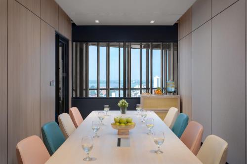 a dining room with a long table and chairs at Capri by Fraser, Phnom Penh in Phnom Penh