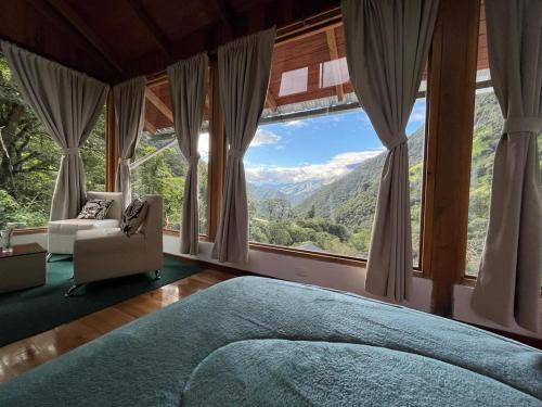 ein Schlafzimmer mit einem Bett und einem großen Fenster in der Unterkunft La Casa de Martin in Baños