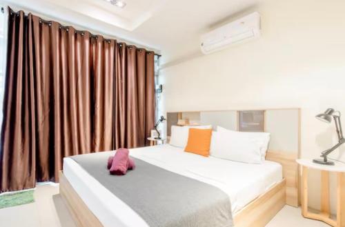 a bedroom with a large bed with brown curtains at CB's - Cheap Boutique Bangkok in Bangkok