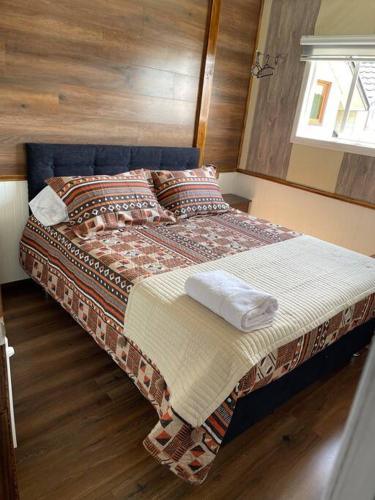 uma cama com duas toalhas num quarto em Departamento centro de Quellón em Quellón