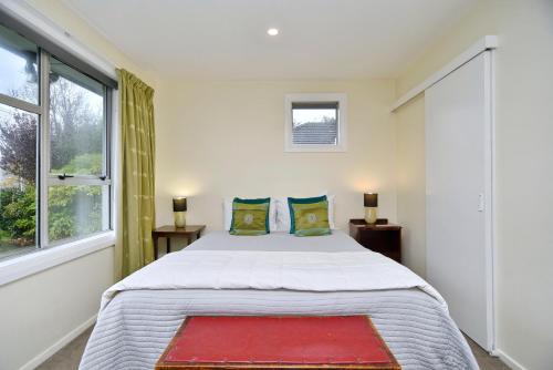a bedroom with a large bed and a window at Charlesworth Villa - Christchurch Holiday Homes in Christchurch