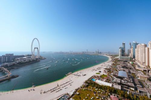 a beach with a ferris wheel in the water at Maison Privee - Jaw-Dropping Sea Vw in Luxury Apt with Delux Fittings in Dubai