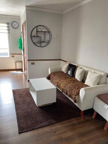 uma sala de estar com uma cama e uma mesa em Departamento centro de Quellón em Quellón