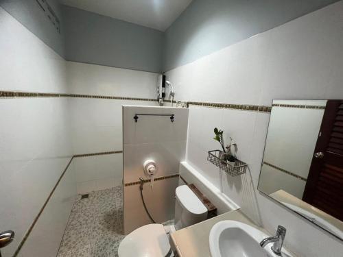 y baño con aseo, lavabo y espejo. en The Sekret Hotel, en Sungai Kolok