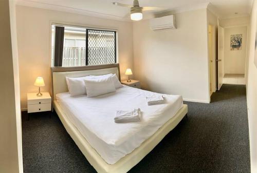 1 dormitorio con 1 cama blanca grande y 2 lámparas en The peaceful place to stay – en Gold Coast