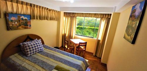 una camera con letto, tavolo e finestra di Carlos Guest House 2 Cusco a Cuzco