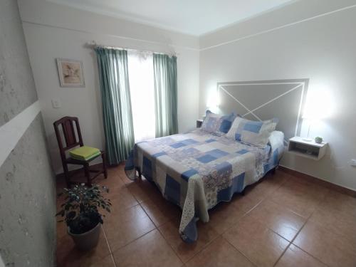 1 dormitorio con 1 cama, 1 silla y 1 ventana en Puñadito de descanso en Salta
