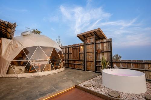 a dome tent on a patio with a bath tub at CLIFF VERANDAH @ DOI LAN in Ban Huai Khai