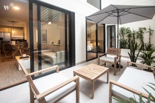 salon z krzesłami, stołami i parasolem w obiekcie Alcanfores by Wynwood House w mieście Lima