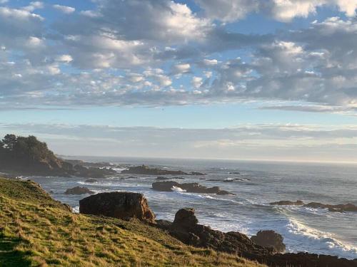 a view of the ocean with rocks on a hill at Amazing ocean views, bright and modern in Sea Ranch
