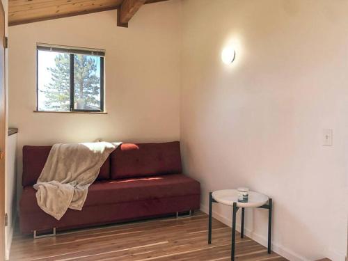 a living room with a red couch and a table at Amazing ocean views, bright and modern in Sea Ranch