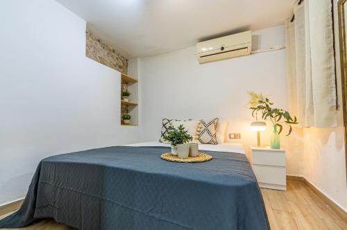 1 dormitorio blanco con 1 cama con manta azul en Lo Petitó de la Part Alta en Tarragona