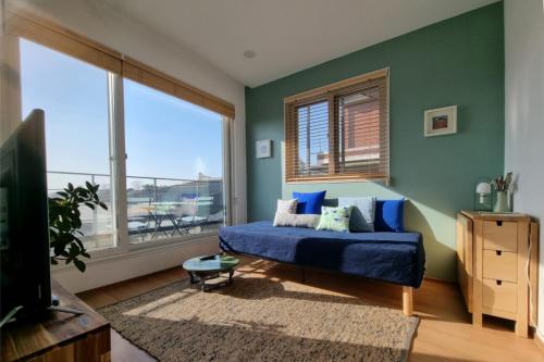 een slaapkamer met een blauw bed en een groot raam bij Naksan Balcony in Seoul