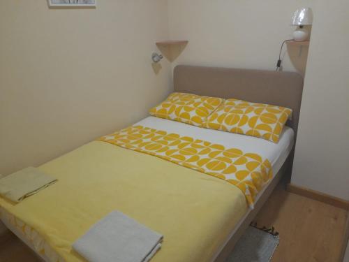 2 Betten in einem kleinen Zimmer mit gelber und weißer Bettwäsche in der Unterkunft Apartment Vanja - 200m from centar city in Krapina