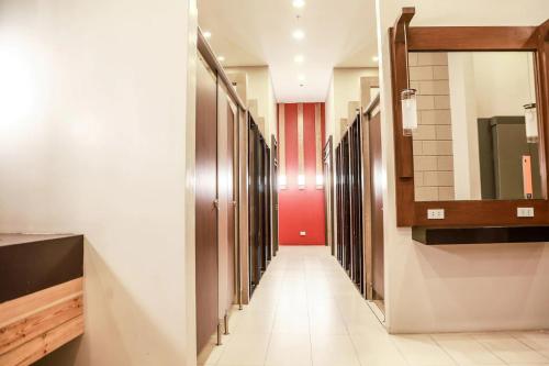 un pasillo con una fila de espejos y un pasillo largo en Sotogrande Hotel Katipunan en Manila