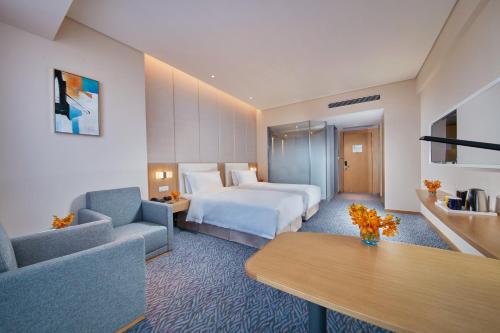 a hotel room with a bed and a couch and a table at Holiday Inn Express Nantong Textile City by IHG in Tongzhou