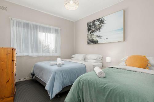 - une chambre avec 2 lits et une photo de la plage dans l'établissement Wanderer by Experience Jervis Bay, à Sanctuary Point