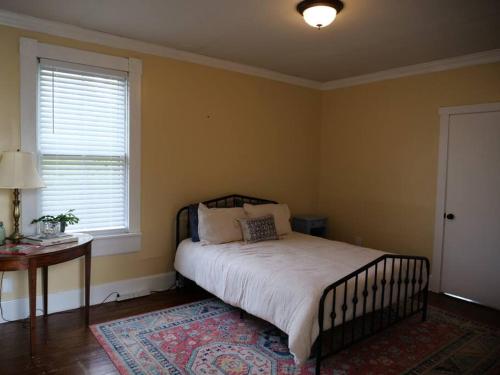 a bedroom with a bed and a table and a window at Historic German Village Home/A+ Downtown Location in Columbus