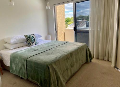 a bedroom with a bed and a large window at Andy & Anna's Weekend Hideaway in Newcastle