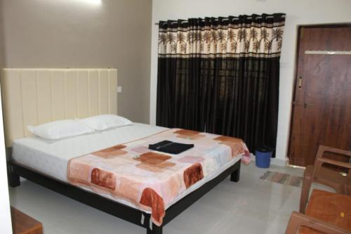 1 dormitorio con 1 cama y una ventana con cortinas en Hope villa homestay en Gokarna