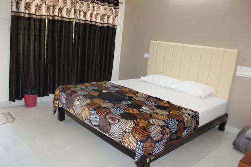 Una cama con edredón en una habitación en Hope villa homestay en Gokarna