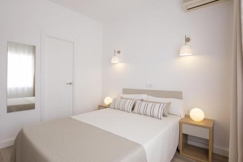 a white bedroom with a white bed and two lights at Cabot Romantic- Adults Only in Port de Pollensa