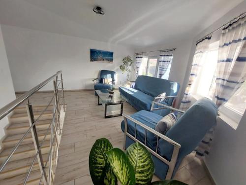 SeaHorse GuestHouse في نافوداري: غرفة معيشة بأثاث ازرق ودرج
