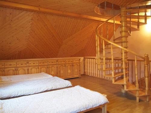 a bedroom with a bed and a spiral staircase at Hajduk Apartment in Międzylesie