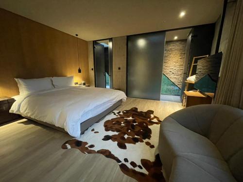 a bedroom with a large bed and a couch at Deer Chaser Hotel in Yuchi