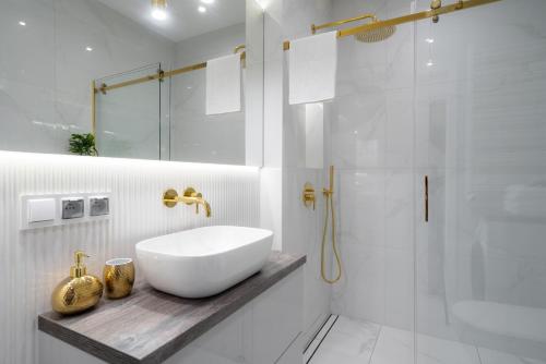 ein weißes Bad mit einem Waschbecken und einer Dusche in der Unterkunft Exclusive Crystal Apartment in Krakau