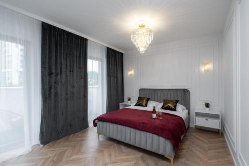 ein Schlafzimmer mit einem Bett mit einer roten Decke und einem Kronleuchter in der Unterkunft Exclusive Crystal Apartment in Krakau
