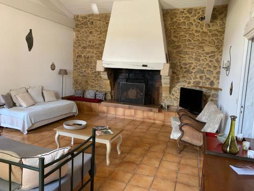 Una sala de estar con un sofá y una chimenea. en Domaine de Bellevue, en Portets