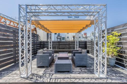 a pergola with chairs and tables on a balcony at ビル泊 -Birupaku Decentralized Hotel- in Shizuoka