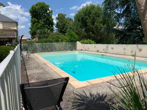 - une piscine dans une cour à côté d'une clôture dans l'établissement Domaine de Bellevue, à Portets