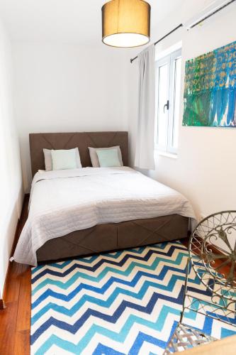 a bedroom with a bed and a rug at Apartments Castello Risano in Risan