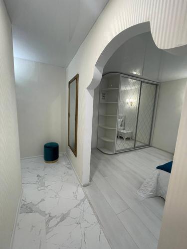 a white room with a bedroom with a mirror at White Apartment in Dnipro