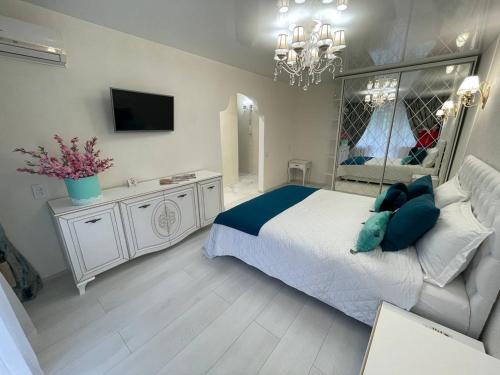 Un dormitorio con una cama grande y una lámpara de araña. en White Apartment, en Dnipro