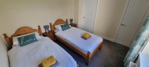 two twin beds in a room withthritisthritislictslictslicts at Benview House in Corpach