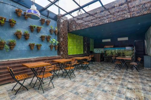 a restaurant with wooden tables and chairs in a room at FabExpress Lemon Grass in Varanasi