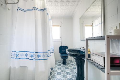 y baño con cortina de ducha y aseo. en Villa Mimosa San Vicente del Raspeig, en San Vicente del Raspeig