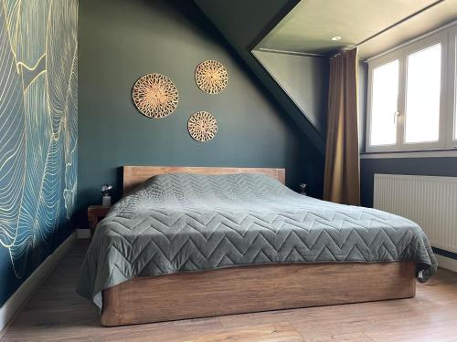 een slaapkamer met een bed en een blauwe muur bij Spacious appartement in scenic quarter with huge roof terrace in Breda